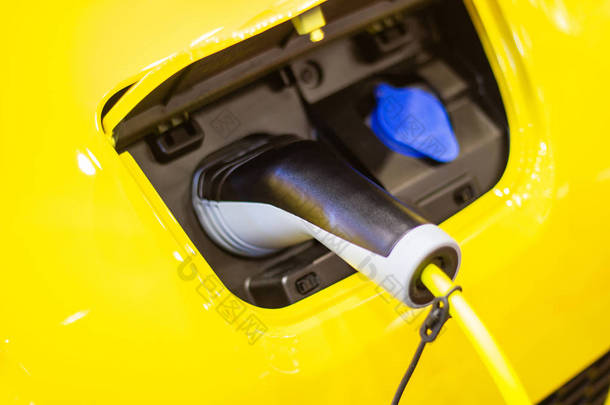 汽车新汽车的充电电池革新电源插在电动汽车上充电，能源创新的概念.