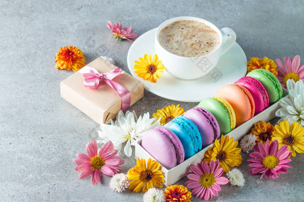 蛋糕马卡龙, 礼品盒, 茶, 咖啡, 卡布奇诺和鲜花的照片。甜蜜浪漫的食物玛卡龙概念。早上的早餐和礼物。情人节概念.