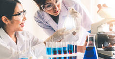 一组身穿实验室外套的科学家在实验室工作，同时用试管和科学仪器检查生物化学样品。科学、技术和发展研究概念.