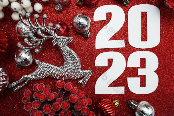 2023年新年快乐装饰圣诞装饰品平铺在鲜红的背景上