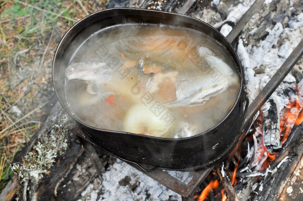 在旅途中着火的制备鱼汤。.