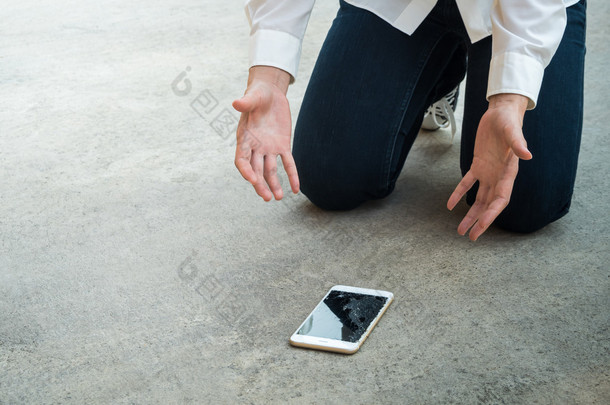 人掉智能手机在地板上