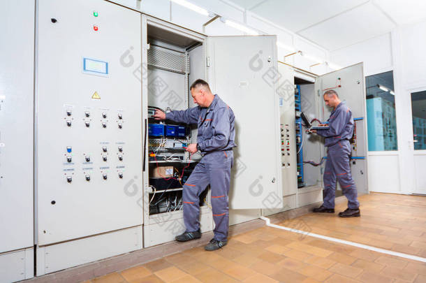 电工测试工业机，电工生成器工程师拧在保险丝盒，男性电工设备