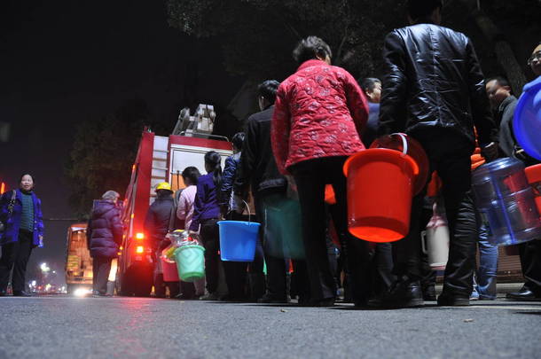 2013年2月25日，中国东部江西省永秀县因漏油污染，6万人的供水被切断后，居民们在社区排队取水。