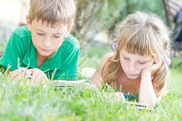 两个年轻快乐的孩子，孩子们阅读的书籍上自然<strong>酒泉</strong>