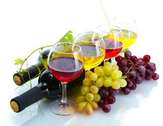 瓶和酒和成熟的葡萄在白色孤立的眼镜