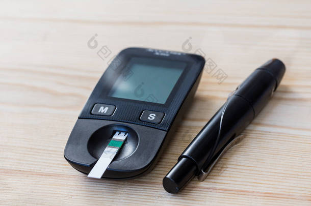 设置血糖和注射器与糖尿病的血糖检测试纸的木材背景