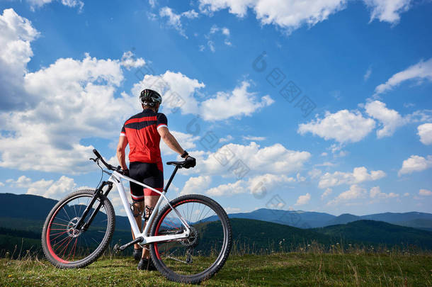 年轻的体育<strong>旅游车</strong>手在职业运动服开始骑自行车在遥远的山, 活跃生活方式和极限体育概念