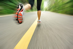 在道路上运行的女性跑步运动员腿部