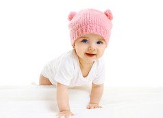 可爱的宝贝肖像匍匐在粉色的针织帽子