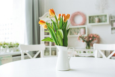 美丽橙色的花，插在花瓶里的乡村厨房桌子上