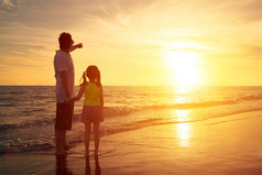 父亲和女儿站在海边看日落