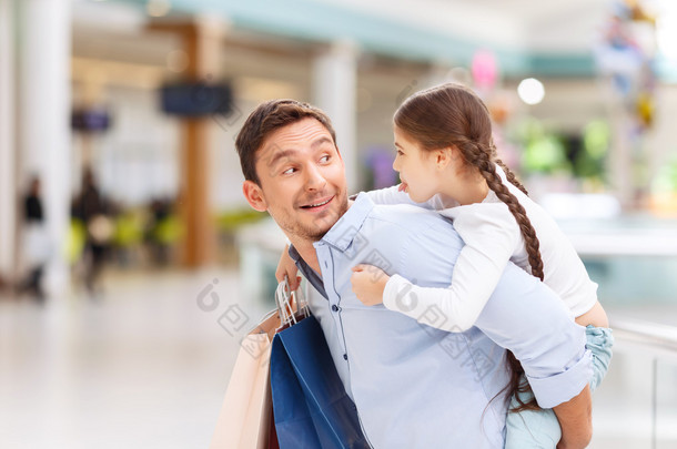 Father and daughter having fun in shopping mall