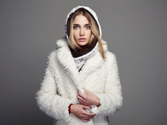 在白色毛皮大衣和敞篷的漂亮女孩。冬季时尚年轻女人