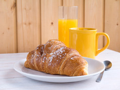 羊角面包、 咖啡和橙汁白色木制的桌子上