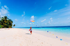 在热带的海滩上放风筝的小男孩