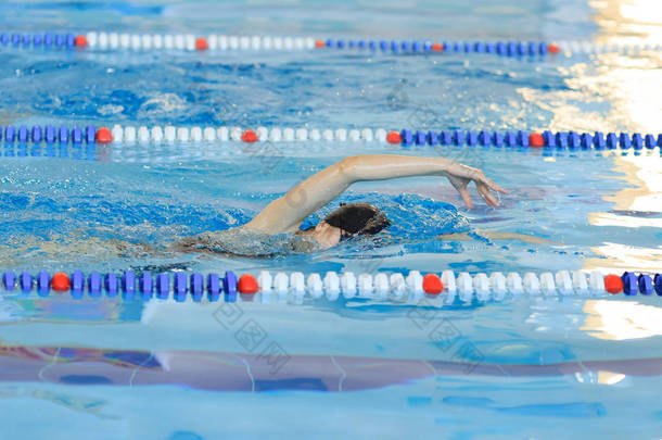 年轻女孩在护目镜和帽蓝色水水池里游泳<strong>自由泳</strong>描边样式.