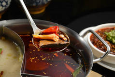 四川火锅-麻辣中国火锅与牛肉、 豆腐、 虾、 蘑菇、 绿色的叶子和面条.