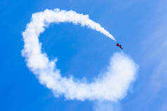红色的打击战斗机，有白色圆圈烟雾背后在蓝蓝的天空