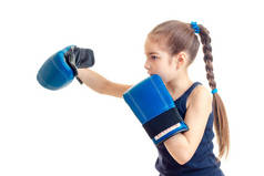 梳辫子的小姑娘婴儿侧身站在摄像机前和向前伸手在大的拳击手套