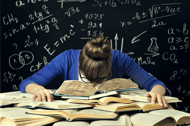 学生努力学习，厌倦了无聊的女人阅读书籍在黑板