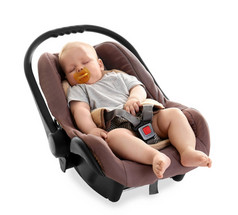 可爱的婴儿与奶嘴睡在儿童安全座椅上的白色隔离