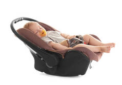 可爱的婴儿与奶嘴睡在儿童安全座椅上的白色隔离