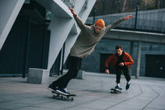 年轻英俊的男子骑着滑板在城市的位置