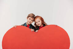 幸福的结合小孩子背后的大红色的心脏孤立灰色