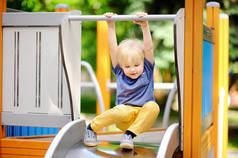 小男孩在户外游乐场/滑梯上玩得开心