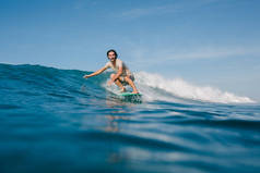 快乐的年轻人穿着湿 t恤在阳光明媚的日子里在冲浪板上骑浪