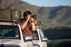 年轻的亚裔男子摄影师在车窗上拍照