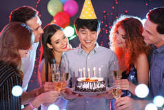 年轻人庆祝生日与蛋糕在夜总会