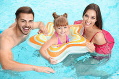 游泳池里有充气环的快乐家庭