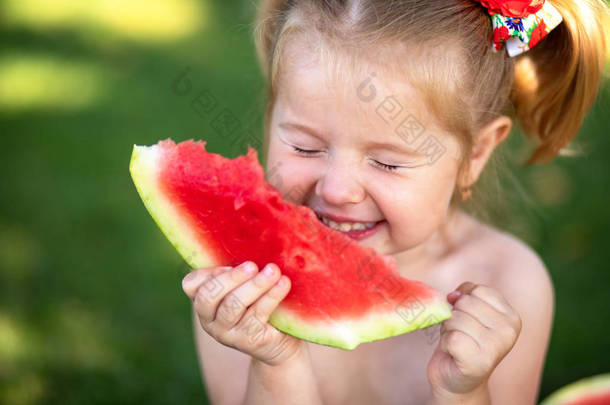孩子在花园里吃西瓜。孩子们在户外吃<strong>水果</strong>。儿童健康小吃。小女孩在花园里拿着<strong>一片</strong>西瓜。儿童园艺
