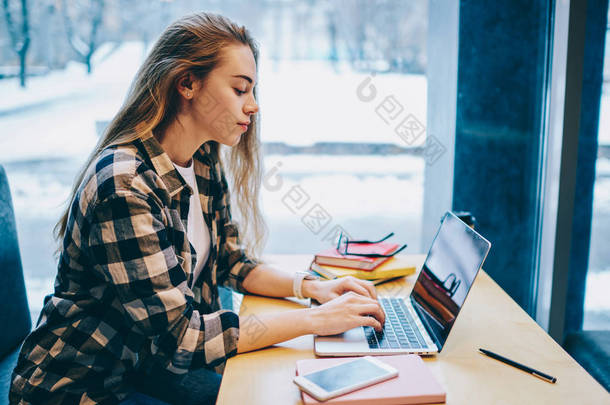 专注于女性博主阅读大学的电子邮件, 并在图书馆学习时通过笔记本电脑输入答案, 美女使用技术在室内搜索信息