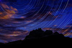 长曝光图像显示夜空星迹越过高山