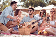 朋友们喝啤酒, 听音乐。在沙滩派对上玩得很开心。暑假, 假期, 假期, 音乐和人的概念.
