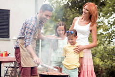 休闲, 食物, 人和假日概念-在夏季户外派对上为家人烹调烤肉烧烤.