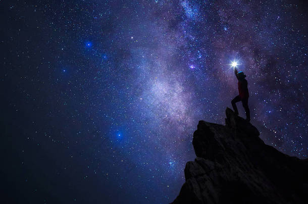 登山者或背包客剪影。在他的手里, 他把灯高高地举在头顶上。<strong>站在</strong>落基山脉<strong>山顶</strong>和银河, 成功, 赢家, 领导理念。高 iso 噪声.