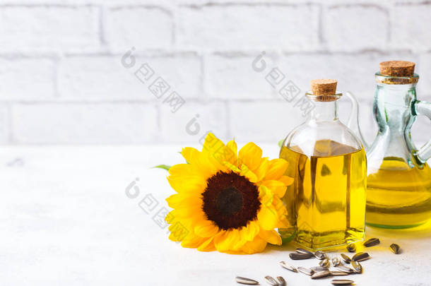 饮食和营养观念。在一张白色的厨房桌子上, 用鲜花在瓶子里配上新鲜的有机特级的向日葵油。复制空间背景