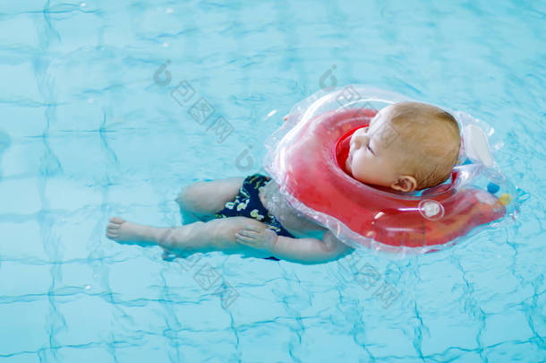 可爱的小<strong>婴儿</strong>学习与在室内<strong>游泳池</strong>游泳圈游泳