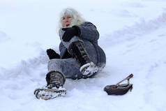 一名女子在寒冷的路上滑倒, 摔倒受伤。倒在被雪覆盖的路上