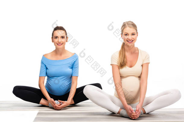 两个孕妇坐在地板上, 手牵着<strong>手脚</strong>孤立在白色