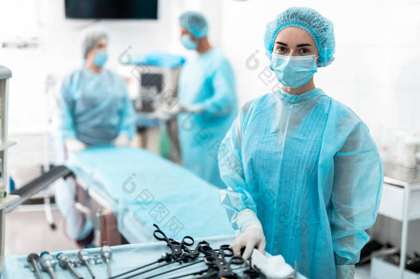 年轻<strong>护士站</strong>在桌旁与腹腔镜仪器