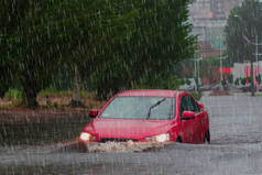 在洪水泛滥的道路上，汽车在大雨中行驶.