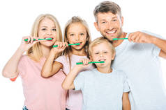 快乐的父母和孩子们一边拿着牙刷一边用白色的牙刷刷牙
