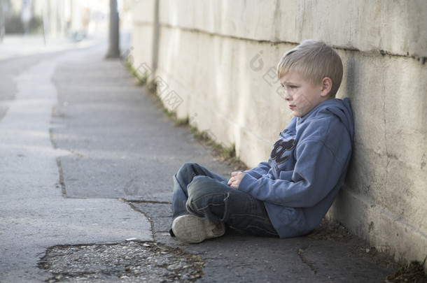 孤独的小男孩坐在通路