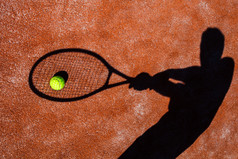 网球运动员在上一个网球场 (面向行动的阴影