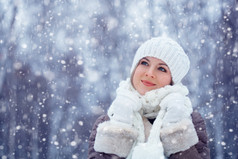 美丽的女人在降雪下户外散步